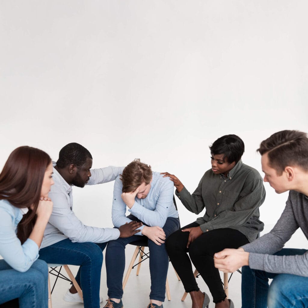 Grupo de apoyo emocional acompañando a una persona en un proceso de tratamiento de adicciones.