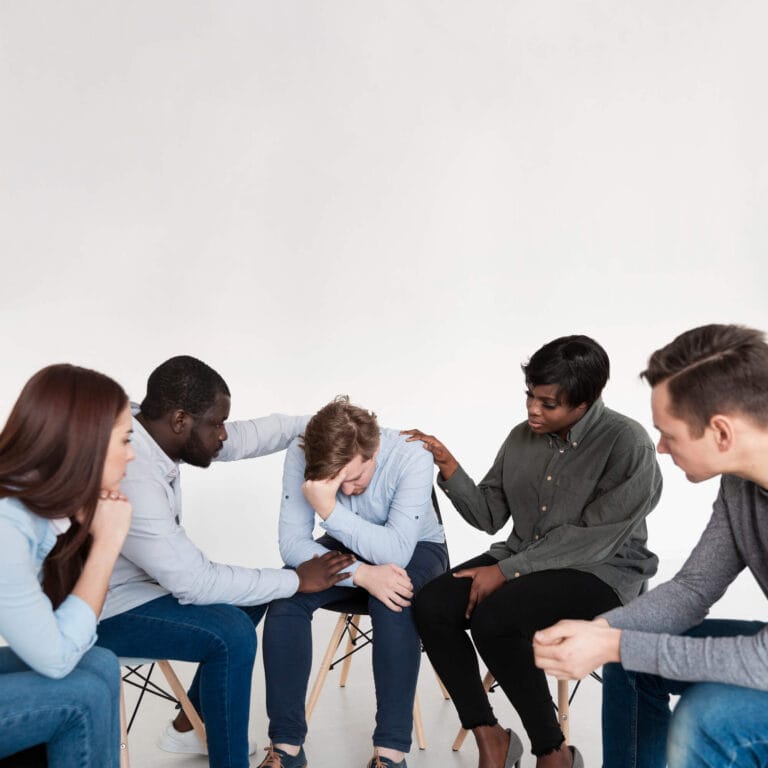 Grupo de apoyo emocional acompañando a una persona en un proceso de tratamiento de adicciones.